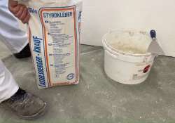 Flexkleber in einen Eimer füllen Flexkleber in einen Eimer füllen