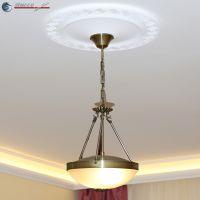 Mäander-Motiv der Stuck Rosette unterstreicht Wirkung der Deckenleuchte